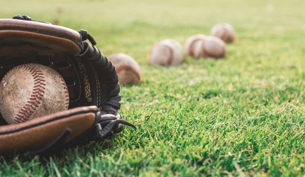 Baseball glove and baseballs in the grass